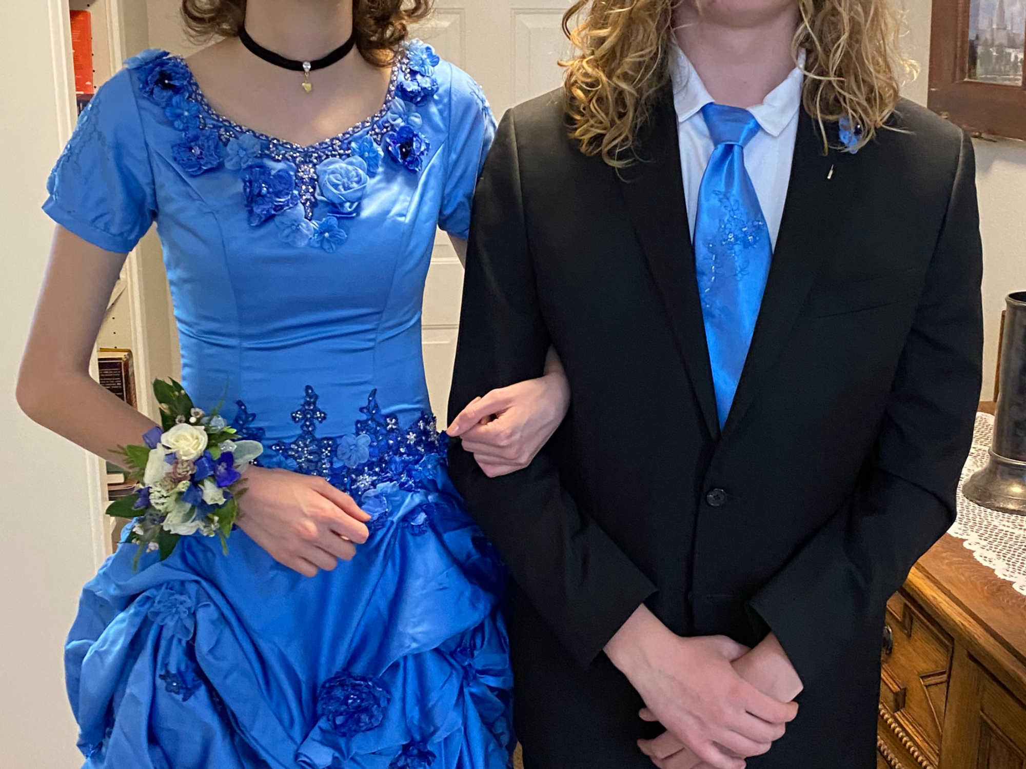 A young woman, wearing a secondhand wedding dress from DI that has been dyed blue, and her Prom date, wearing a tie made from the same dyed material as the dress.